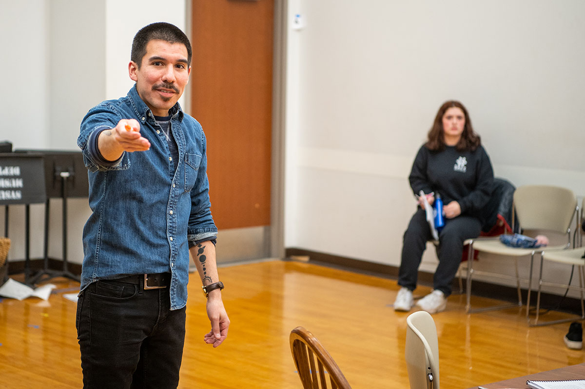 A man in a blue shirt point